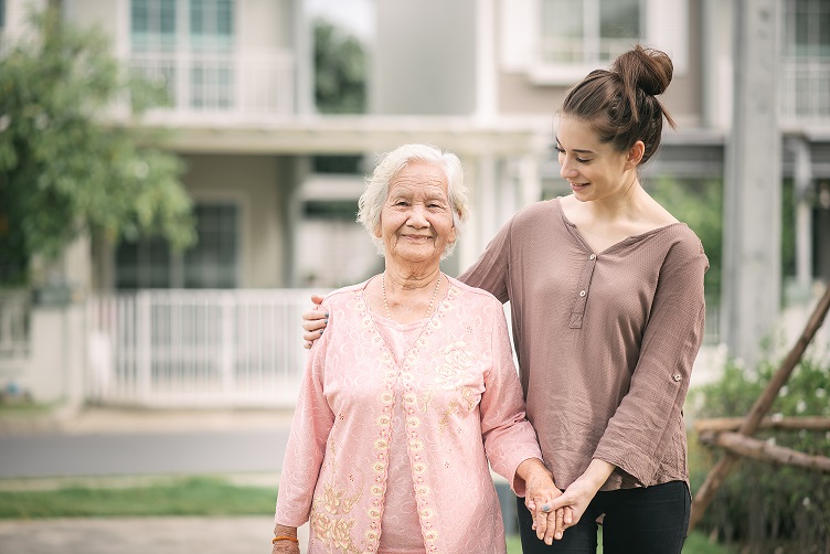 Caregiver embracing elderly woman