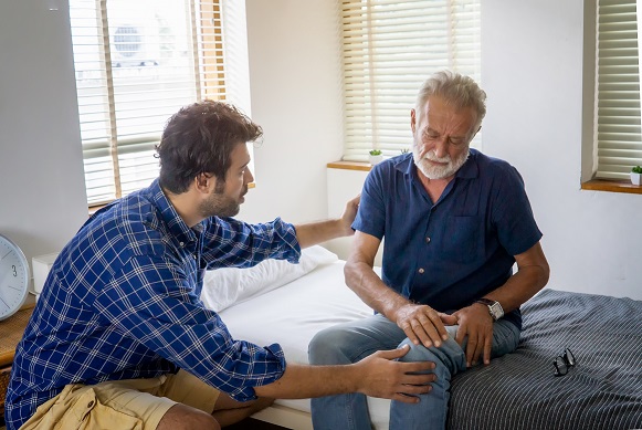 Male caregiver helping elderly man