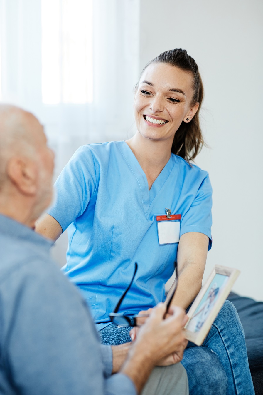 Nursing assistant smiles at an elderly man