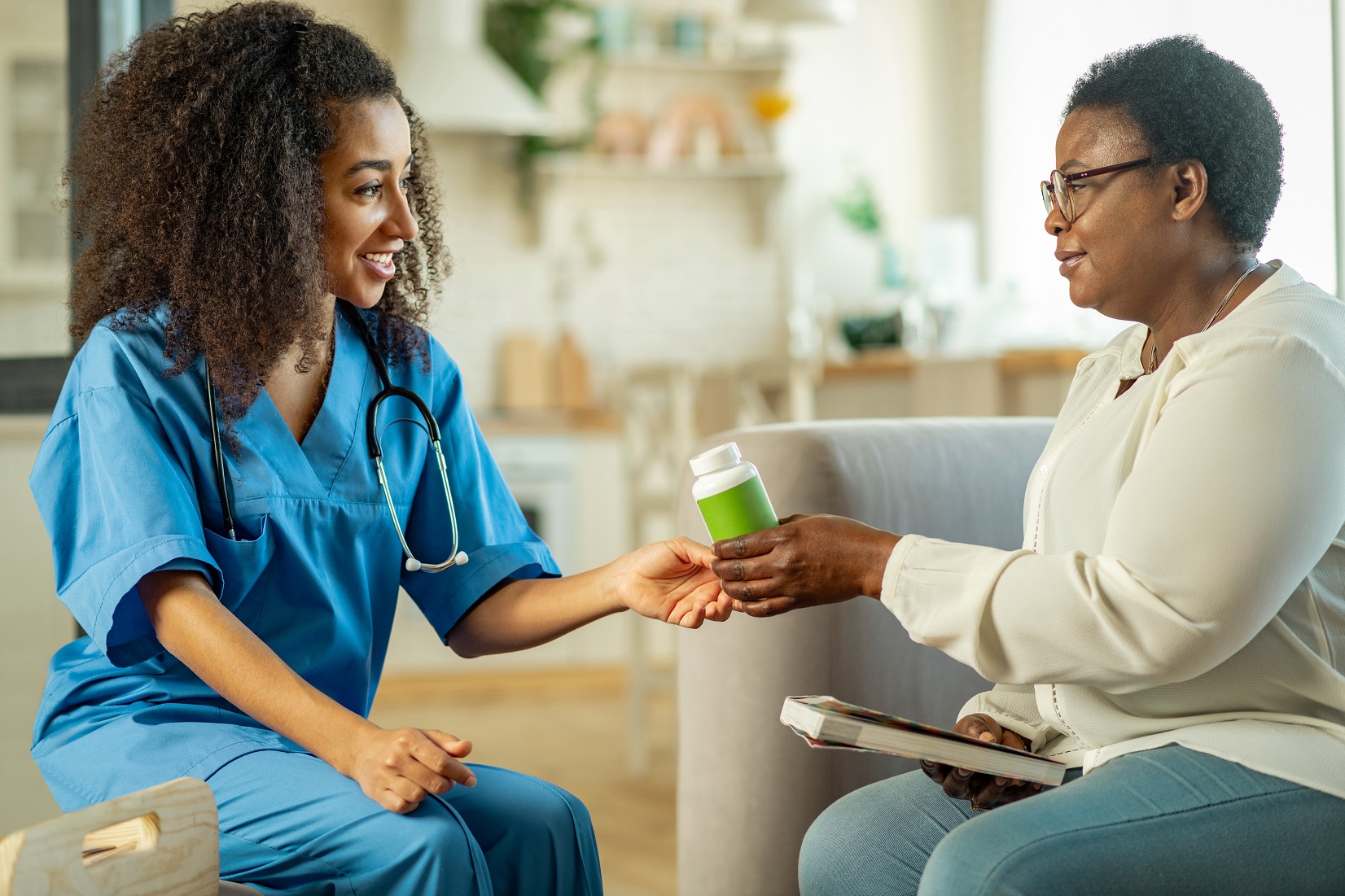 Female caregiver helps woman with medicine